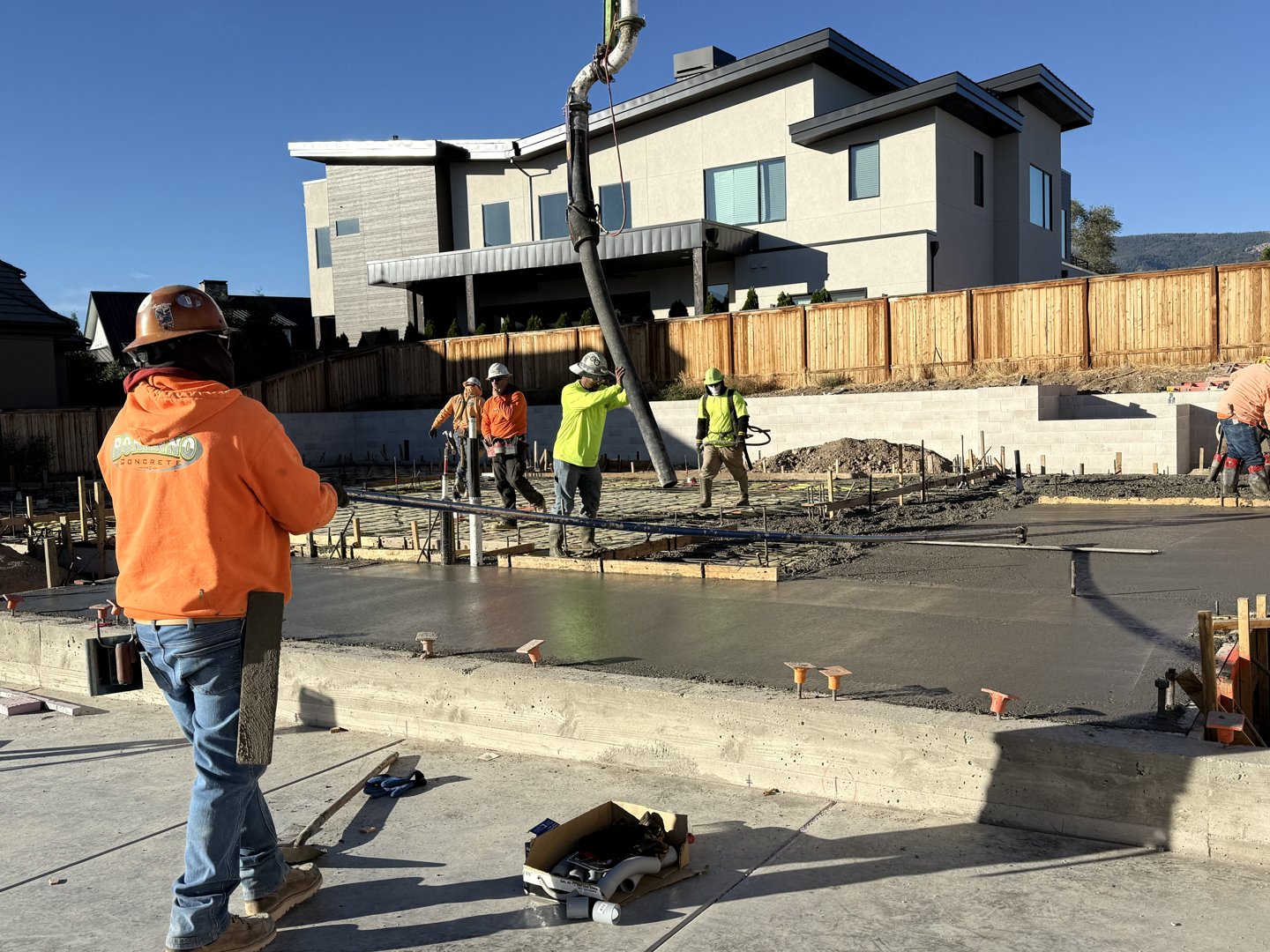 Crew placing and screeding the slab with the pump boom overhead