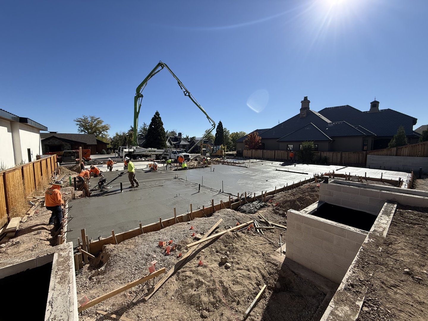 Crew finishing a section of the slab beside the foundation walls