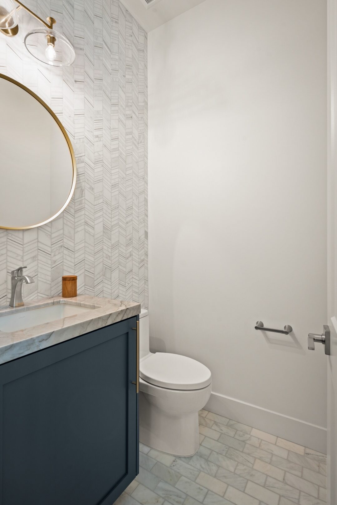 Navy powder room with chevron marble