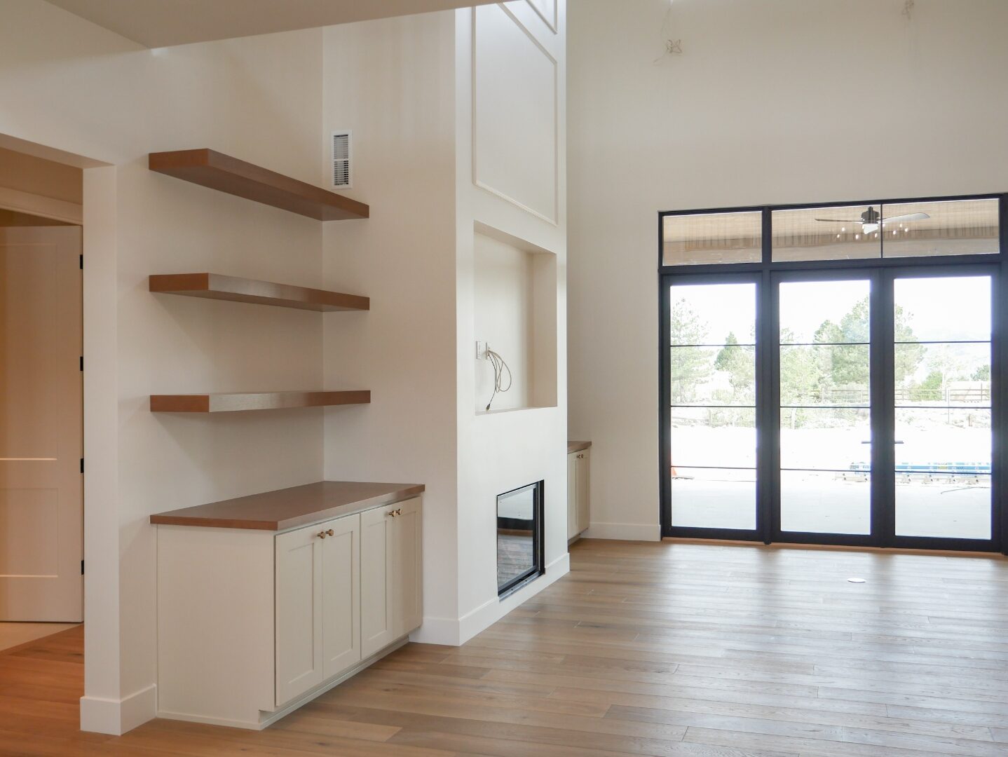 Great room fireplace and shelving with steel-framed doors to the yard